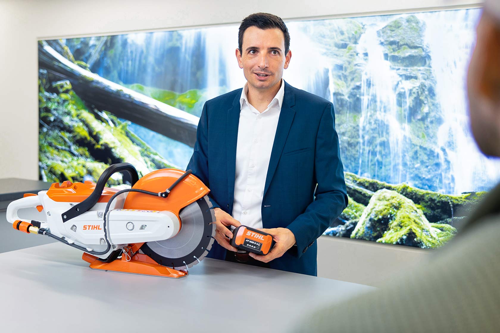 Max Dopatka steht an einem Tisch, vor sich einen Akku-Trennschleifer