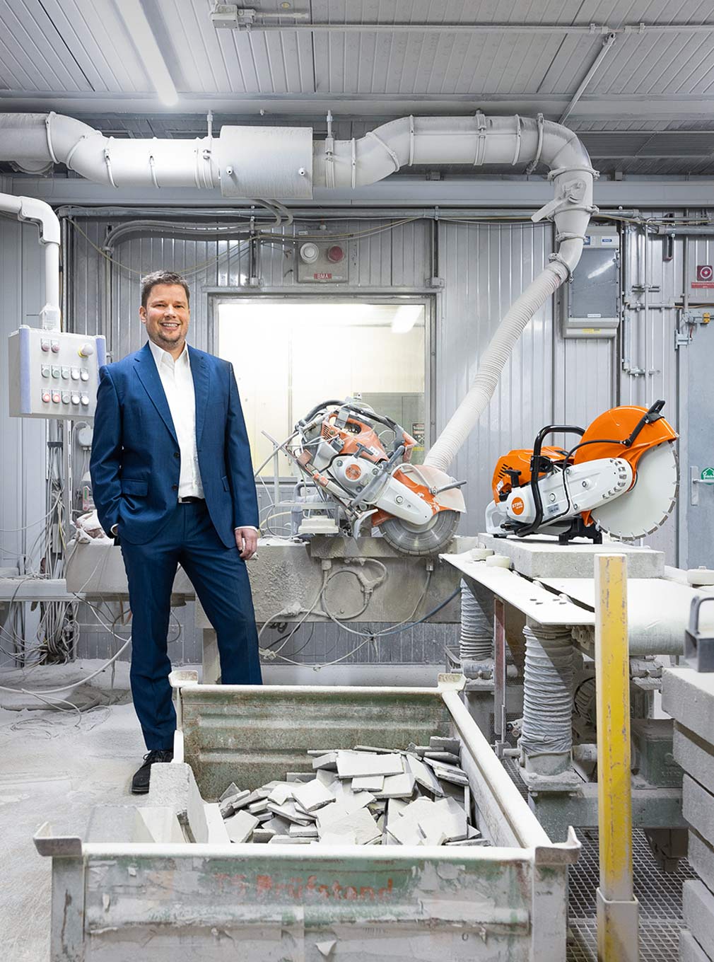 Stefan Merkle steht vor einem Teststand Prüfstand für Benzin-Trennschleifer